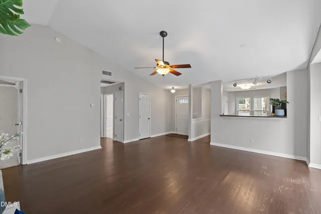 a view of empty room with wooden floor fireplace and window