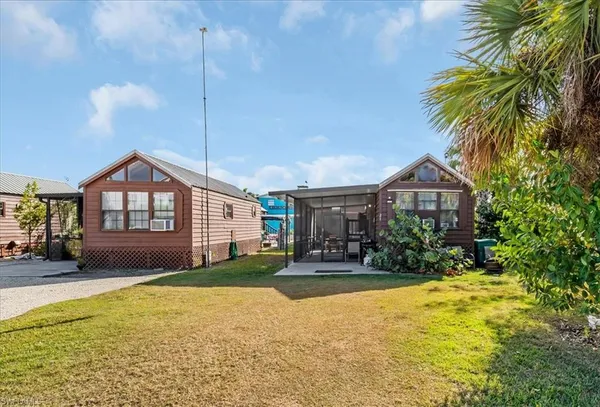 a front view of house with yard and trees in the background