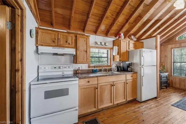 a kitchen with white cabinets and white appliances