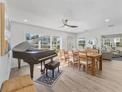 a kitchen with stainless steel appliances granite countertop a table chairs sink refrigerator and cabinets