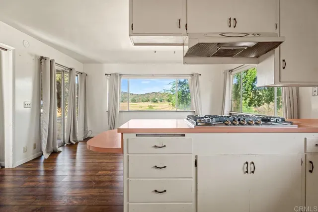 a kitchen with a stove a refrigerator and a window