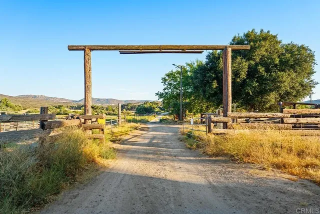a view of a swimming pool with a lawn chairs under an umbrella