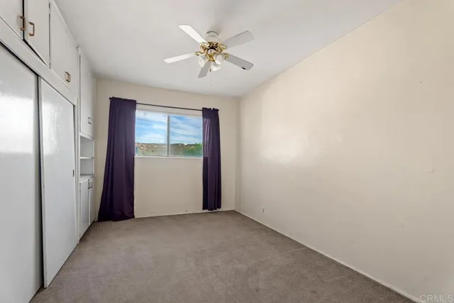 an empty room with closet and windows