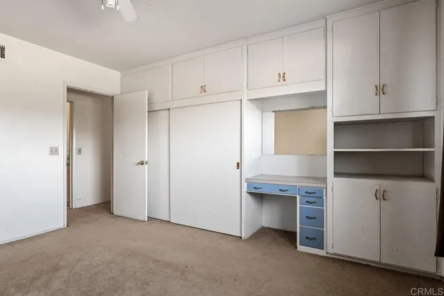 a view of an empty room with cabinet and entryway