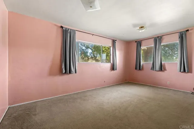 an empty room with windows and closet