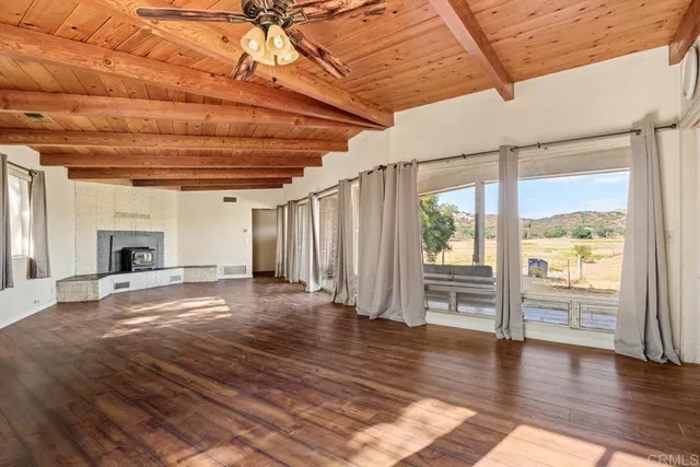 a view of empty room with wooden floor and fireplace