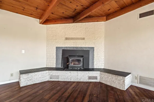 a view of empty room with wooden floor and fireplace