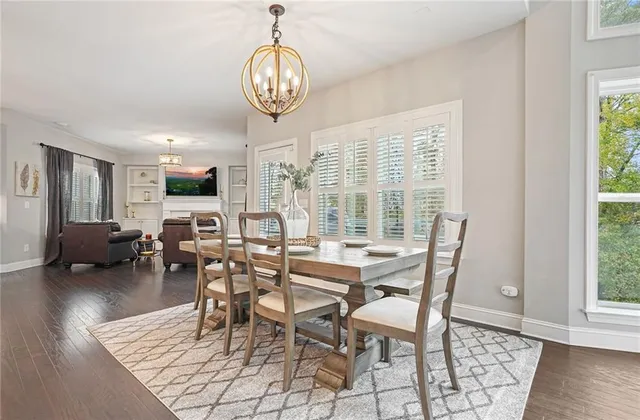 a view of a dining room and livingroom with furniture wooden floor a chandelier