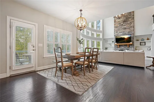 a very nice looking dining room with wooden floor and a chandelier