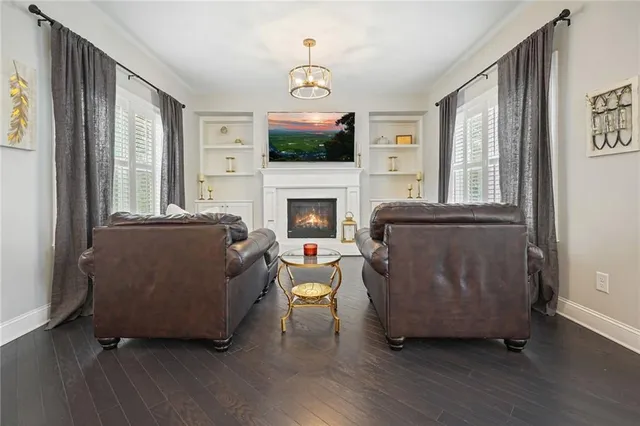 a spacious bedroom with a bed a chandelier and glass door