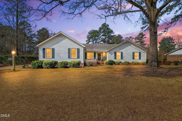 a front view of a house with a garden and yard