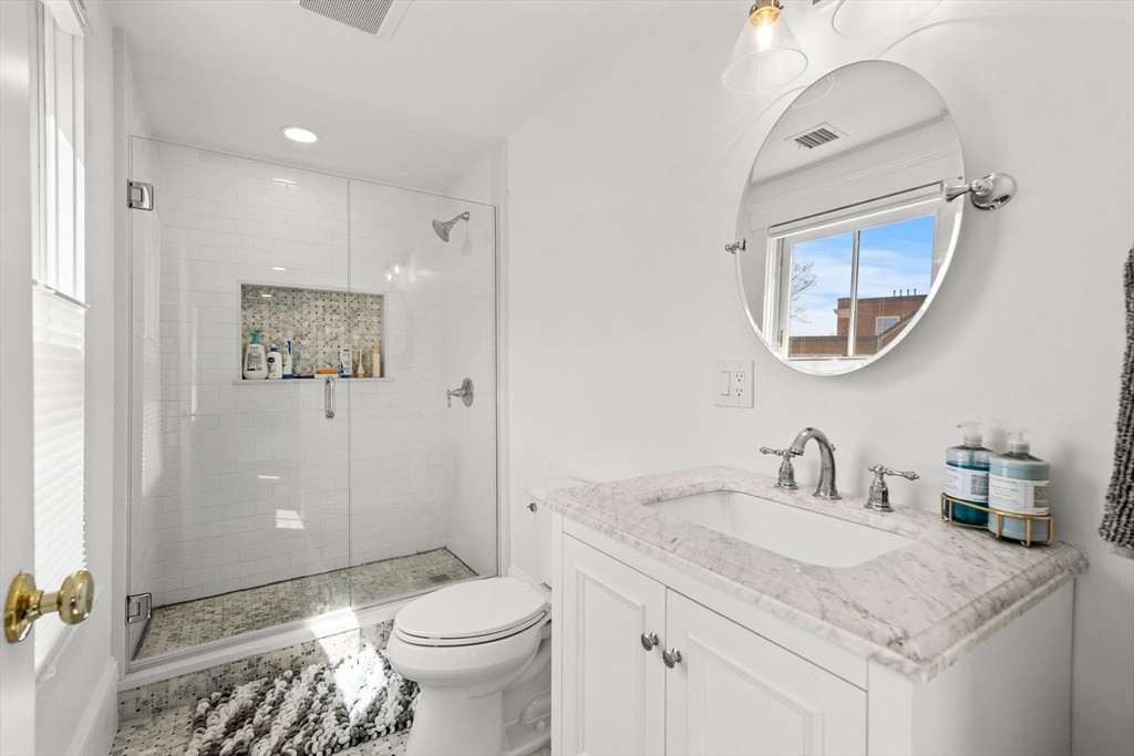 23 Union Street, Unit 2 Salem, MA 01970 - Photo 20 of 33 a bathroom with a granite countertop sink toilet and a mirror