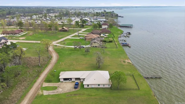 an aerial view of a house with a yard and lake view