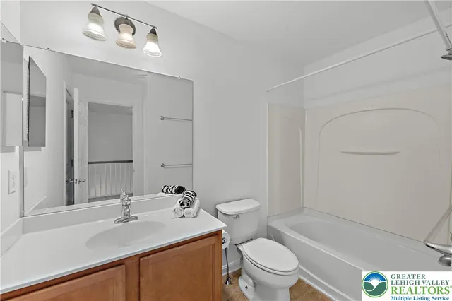 a bathroom with a sink toilet vanity and tub