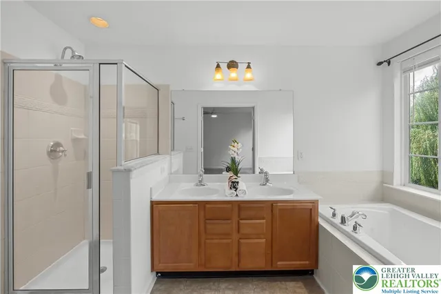 a bathroom with a tub sink and mirror