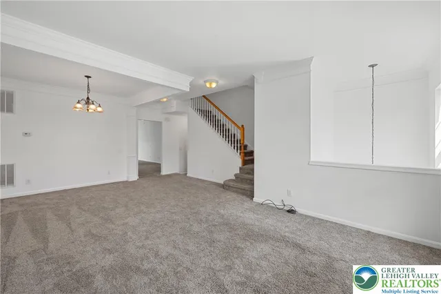 an empty room with ceiling fan and window