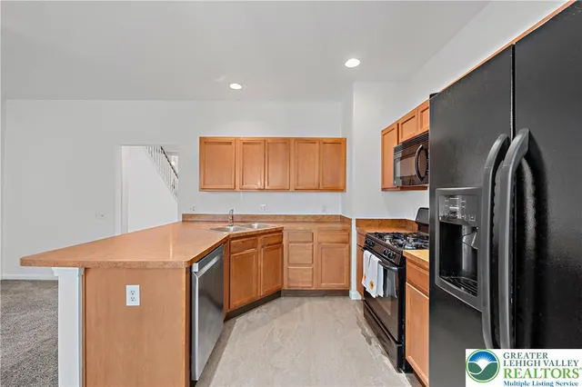 a kitchen with stainless steel appliances granite countertop a refrigerator and a stove