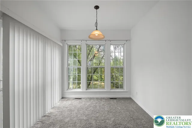 a view of a room with large windows and chandelier