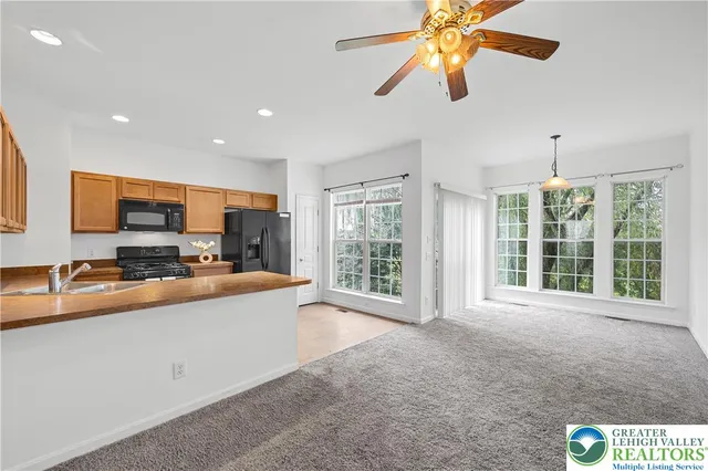 a view of a kitchen with stainless steel appliances granite countertop a sink and a stove