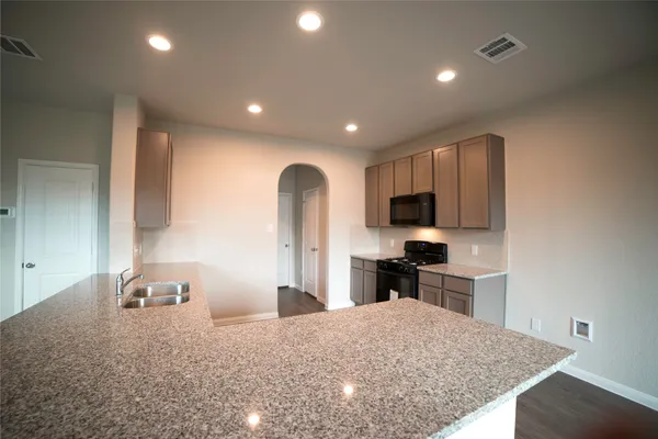 a kitchen with granite countertop a sink stainless steel appliances and cabinets