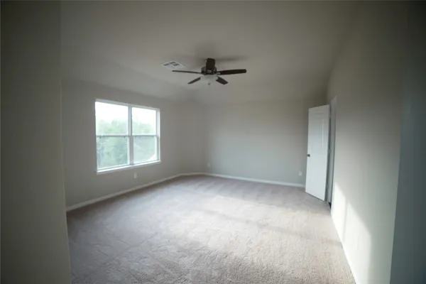 an empty room with a window and a fan