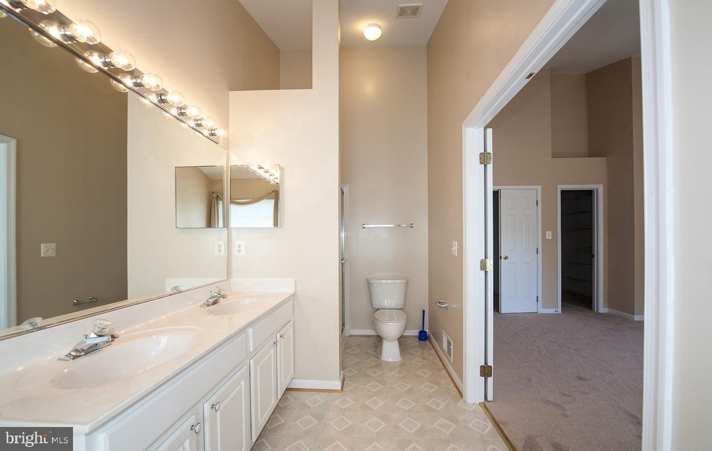 6727 Sullivan Way Alexandria, VA 22315 - Photo 13 of 24 a spacious bathroom with a double vanity sink a mirror and a toilet