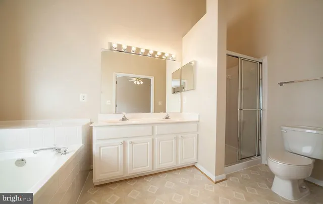 a bathroom with a double vanity sink toilet and shower