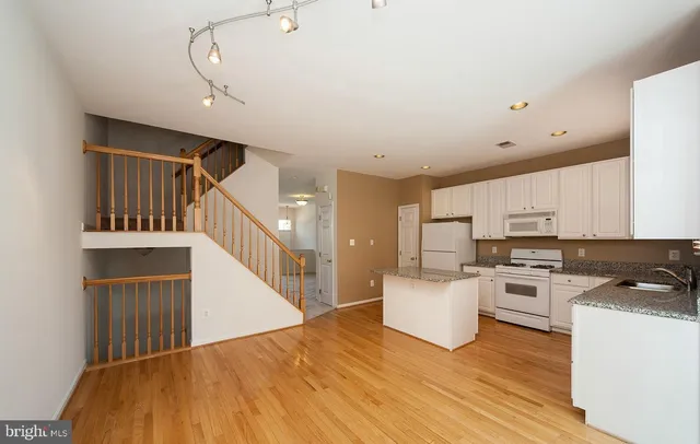 a kitchen with cabinets and wooden floor