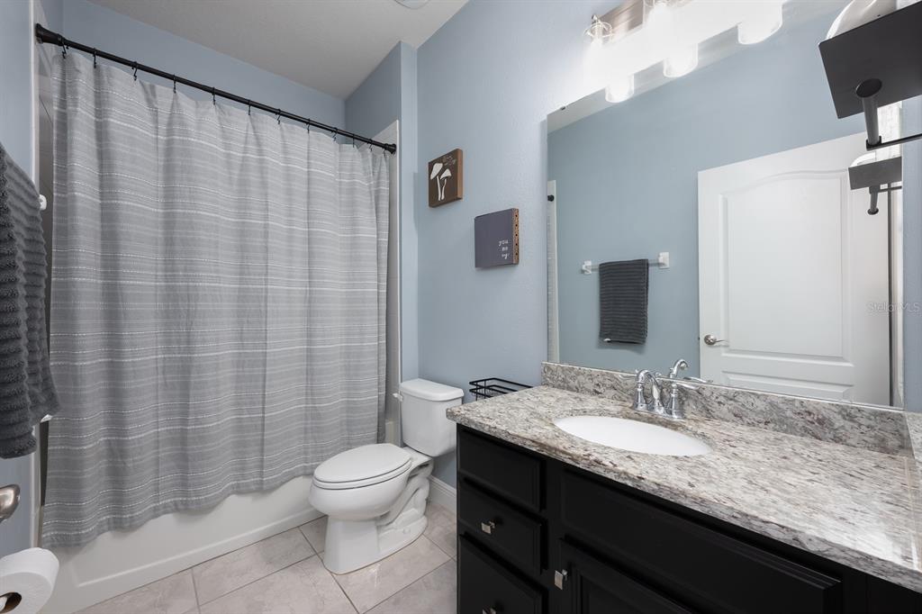 1398 Riley Circle Deland, FL 32724 - Photo 12 of 29 a bathroom with a granite countertop sink toilet a mirror and shower curtain