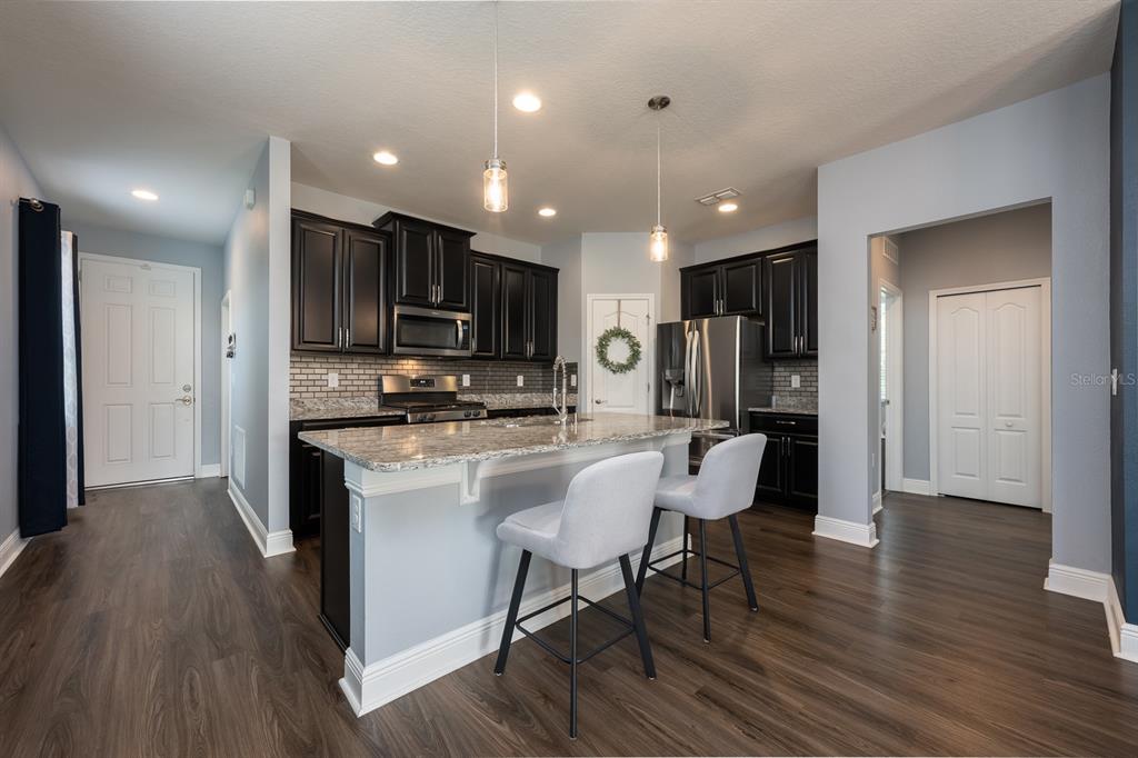 1398 Riley Circle Deland, FL 32724 - Photo 2 of 29 a kitchen with stainless steel appliances kitchen island granite countertop a refrigerator and a stove top oven
