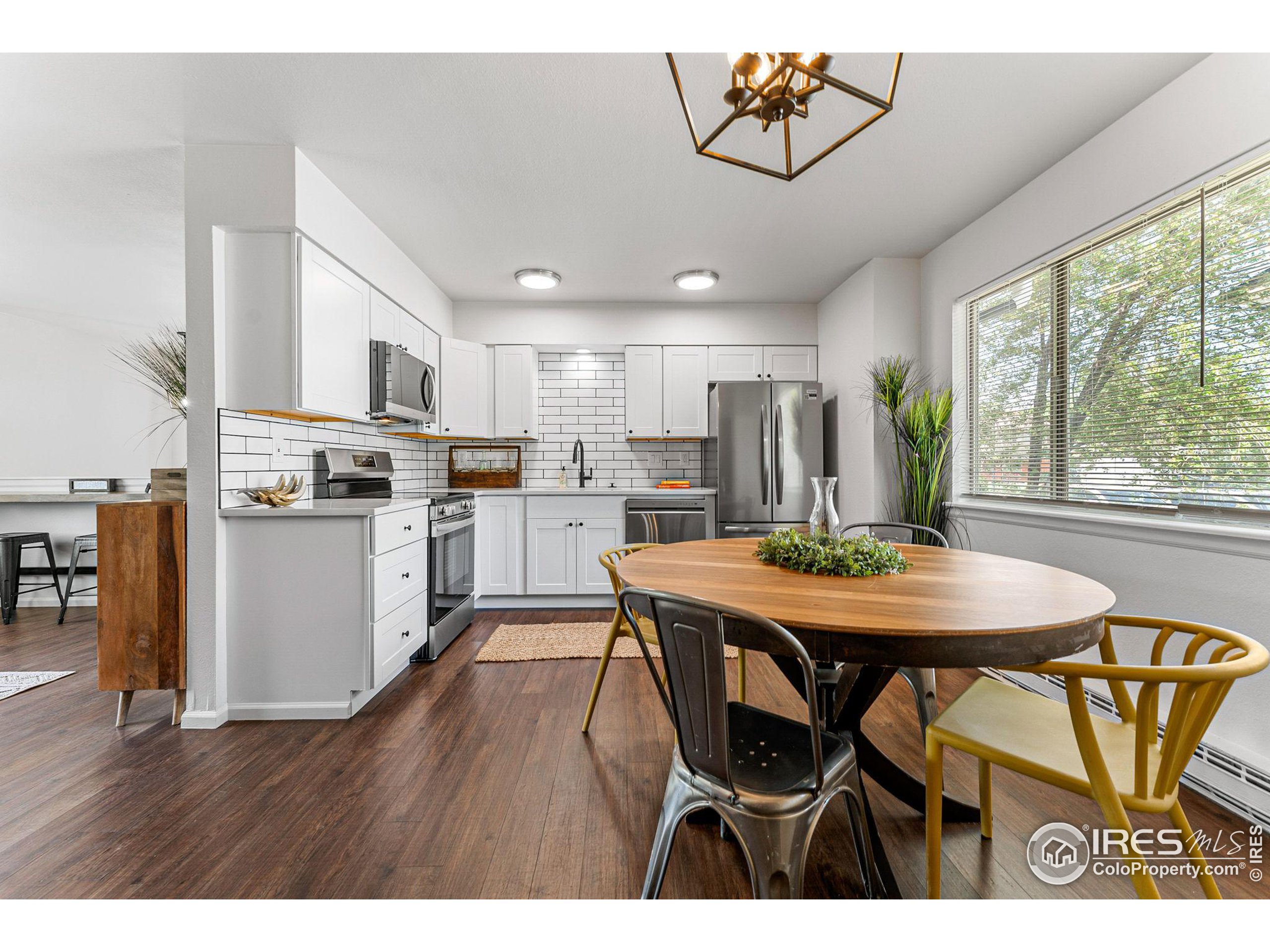2408 Orchard Place Fort Collins, CO 80521 - Photo 13 of 36 a kitchen with stainless steel appliances granite countertop a dining table chairs and granite counter tops