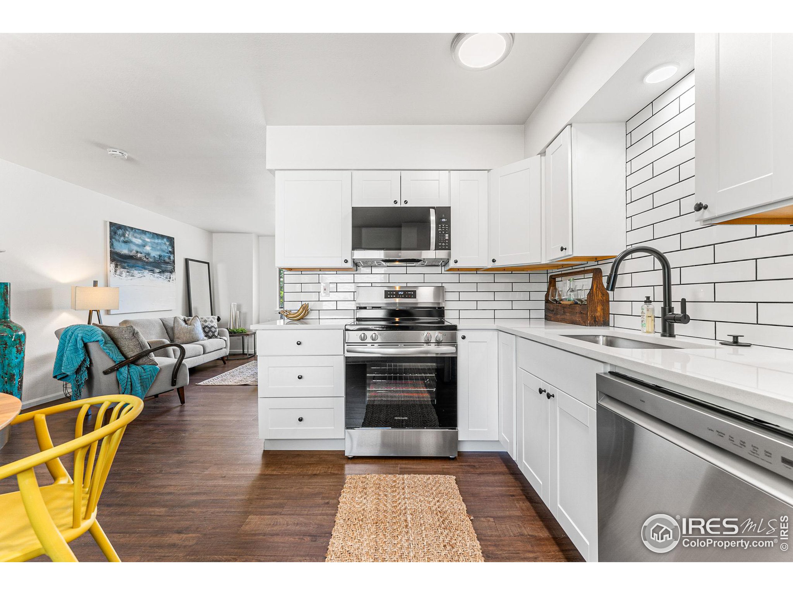 2408 Orchard Place Fort Collins, CO 80521 - Photo 14 of 36 a kitchen with stainless steel appliances a stove a sink dishwasher and a microwave oven with white cabinets