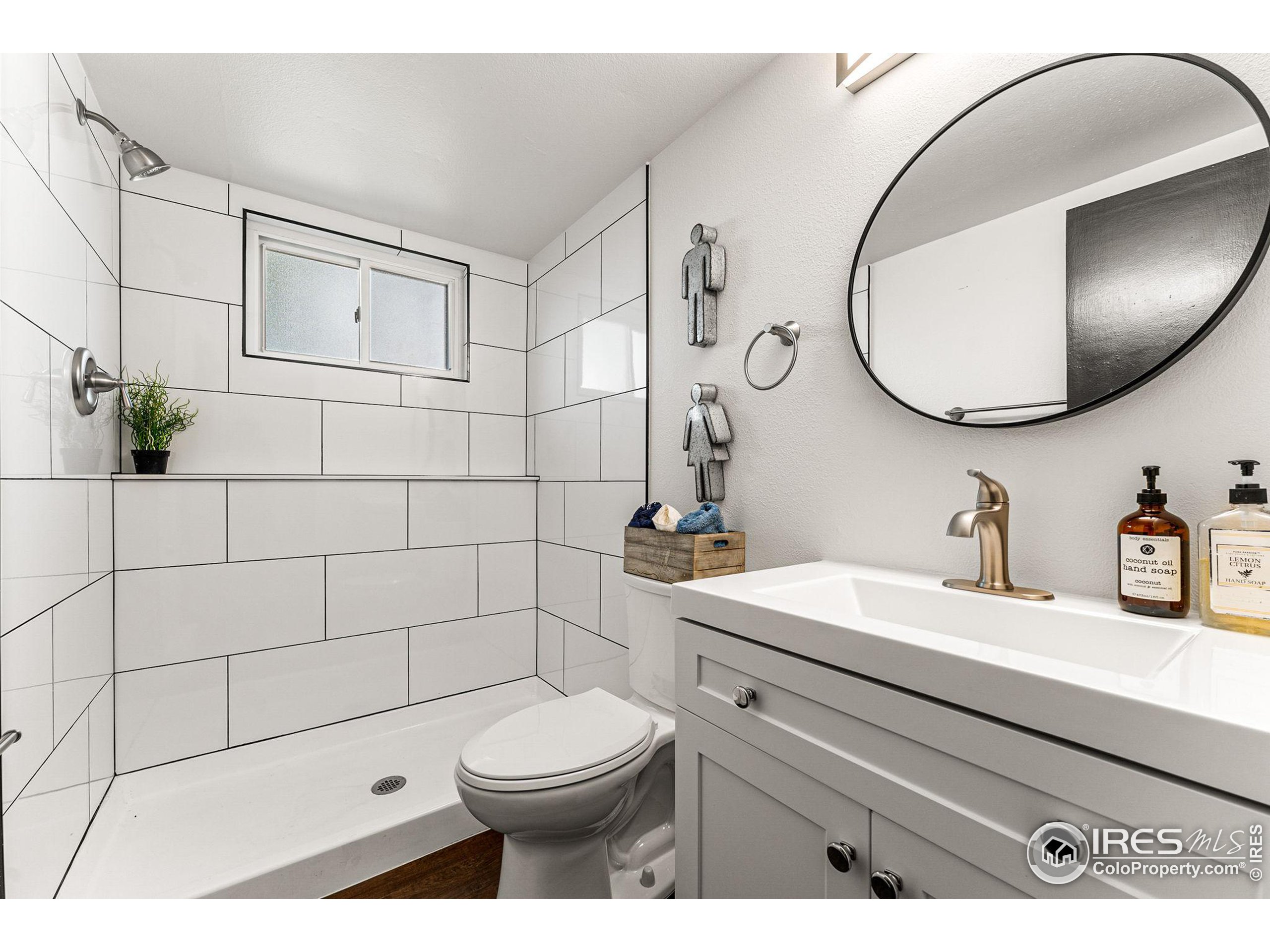 2408 Orchard Place Fort Collins, CO 80521 - Photo 28 of 36 a bathroom with a toilet a sink and mirror