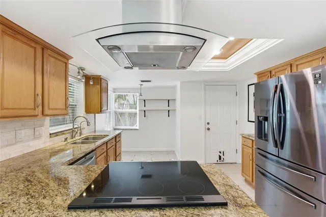 a view of a kitchen with stainless steel appliances granite countertop a refrigerator and a sink