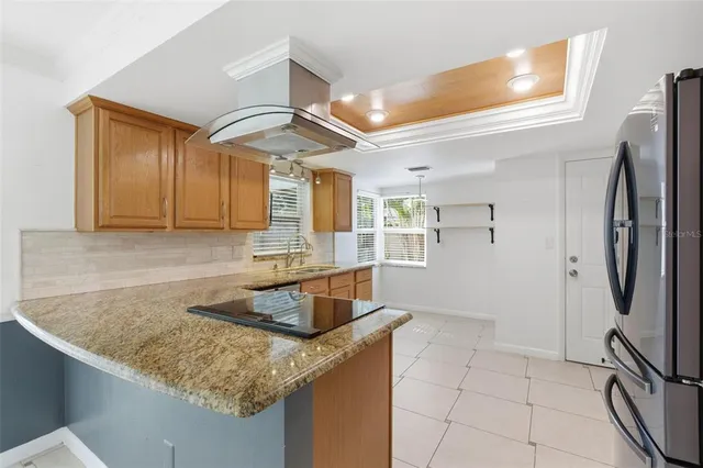 a kitchen with stainless steel appliances granite countertop a sink a refrigerator and a granite counter tops