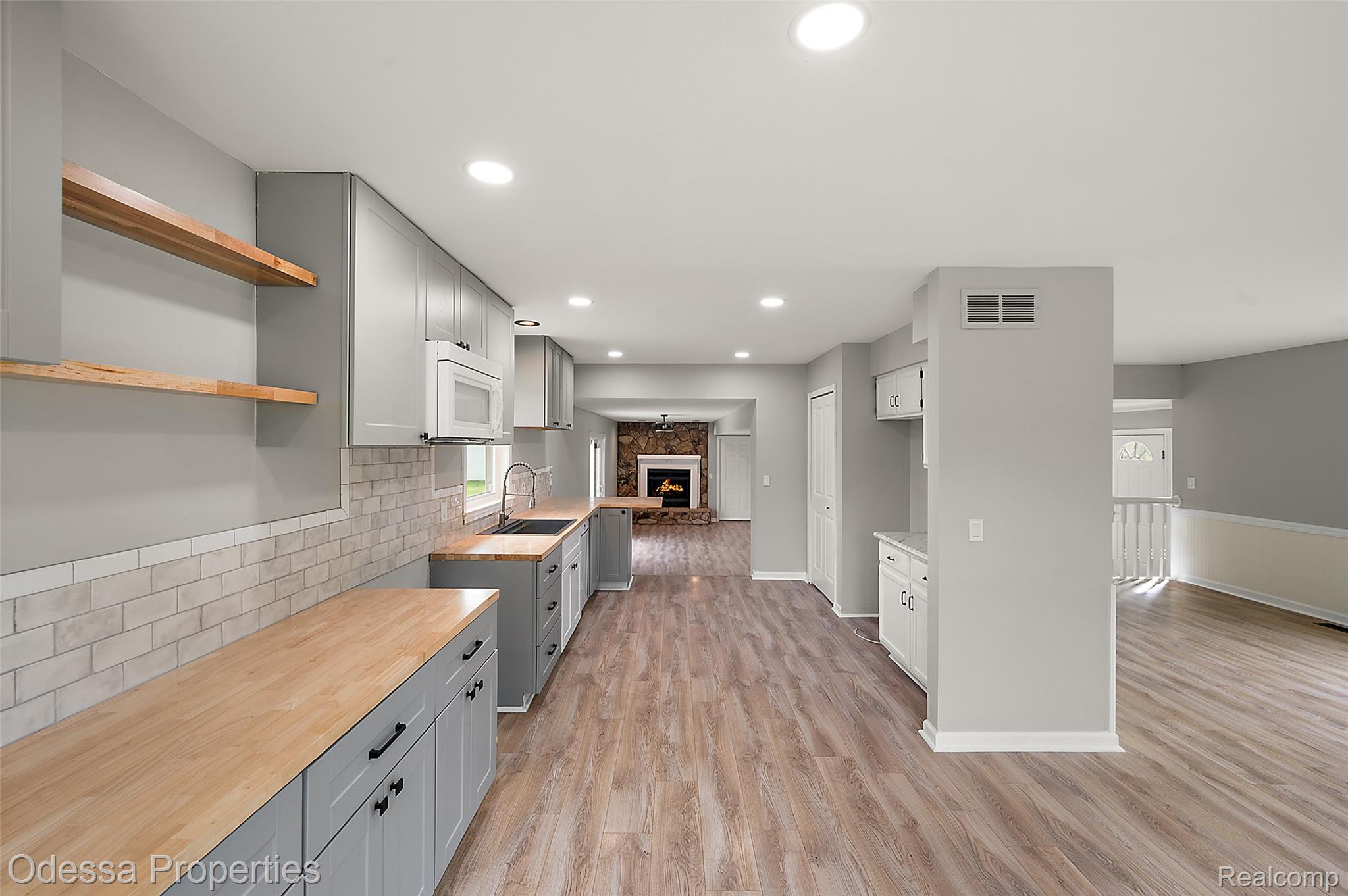 1442 Riley Center Road Memphis, MI 48041 - Photo 10 of 62 Kitchen with a lit fireplace, recessed lighting, tasteful backsplash, light wood-type flooring, and open shelves