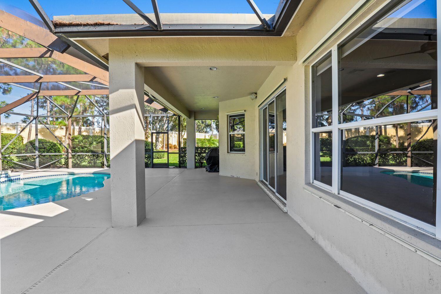 9152 Short Chip Circle Port St. Lucie, FL 34986 - Photo 32 of 72 a view of a porch with a floor to ceiling window and wooden fence