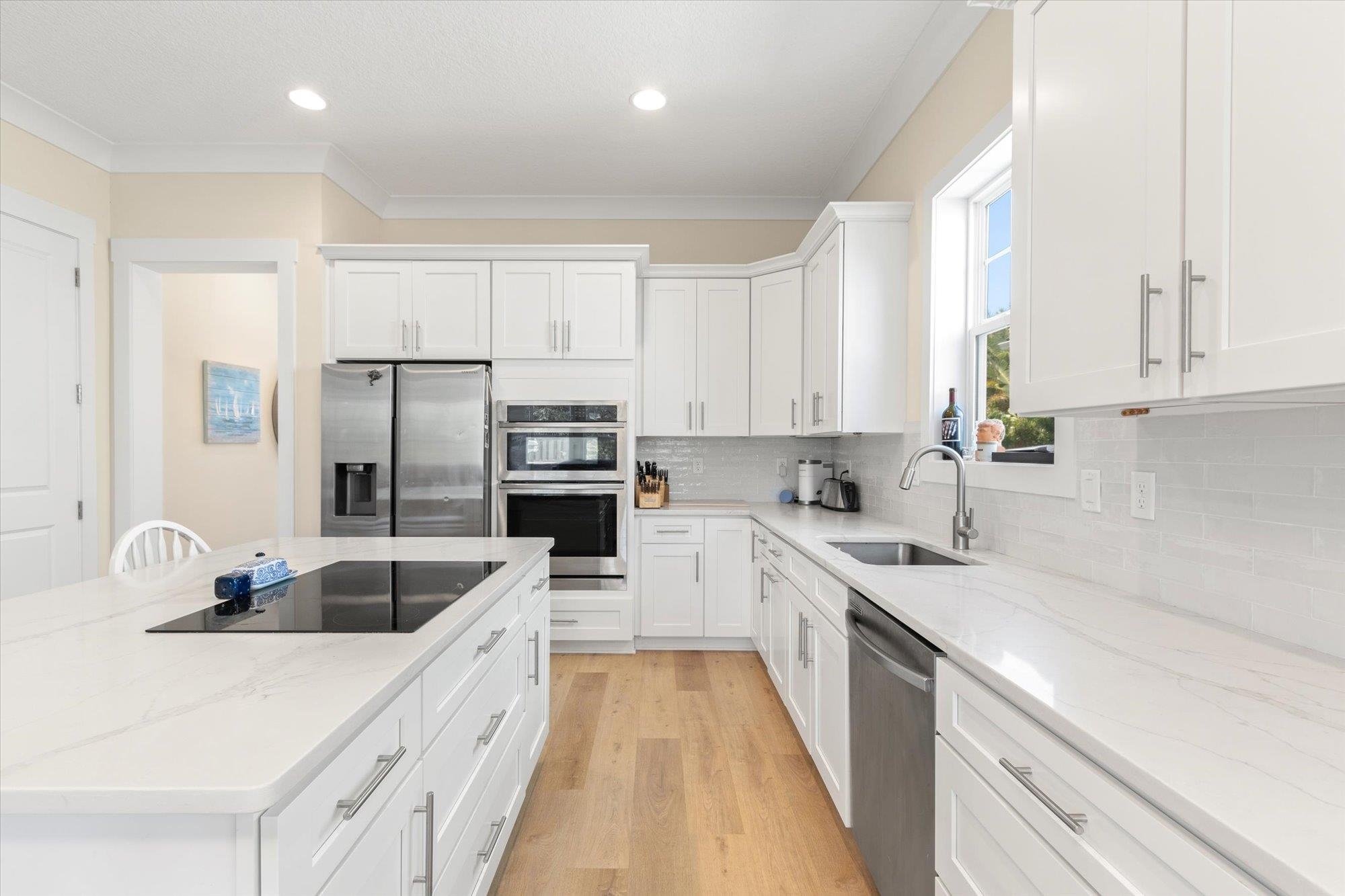 125 5th Street St. Augustine, FL 32080 - Photo 7 of 51 a kitchen with white cabinets sink and stainless steel appliances