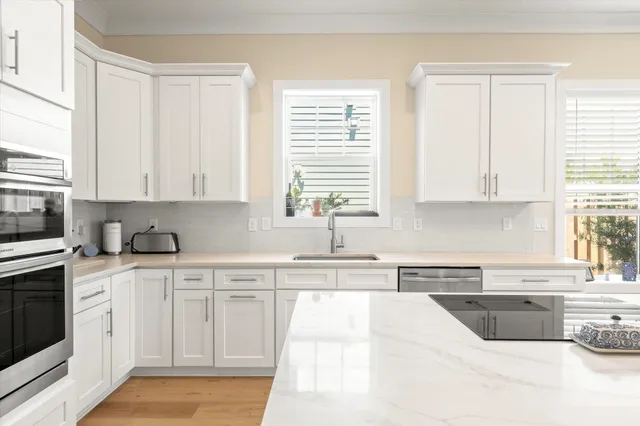 a kitchen with stainless steel appliances granite countertop a sink a stove a microwave and cabinets