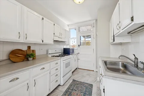 a kitchen with white cabinets and white appliances