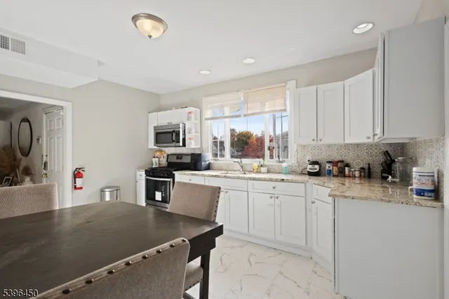 a kitchen that has a sink a stove counter top space and cabinets