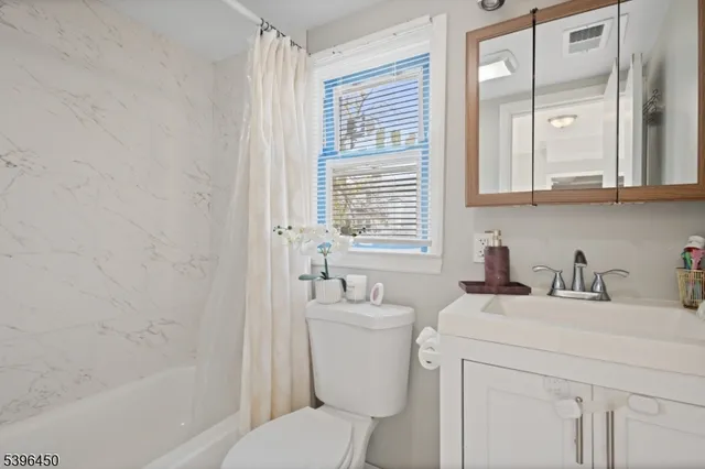 a bathroom with a sink toilet vanity and tub