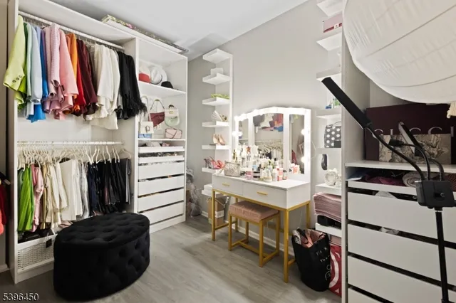 a view of walk in closet with clothes and shoes