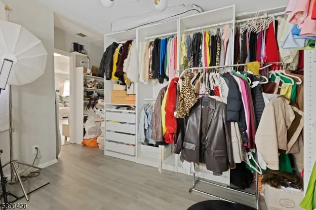 a view of walk in closet with clothes