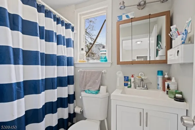 a bathroom with a sink a toilet and a shower curtain