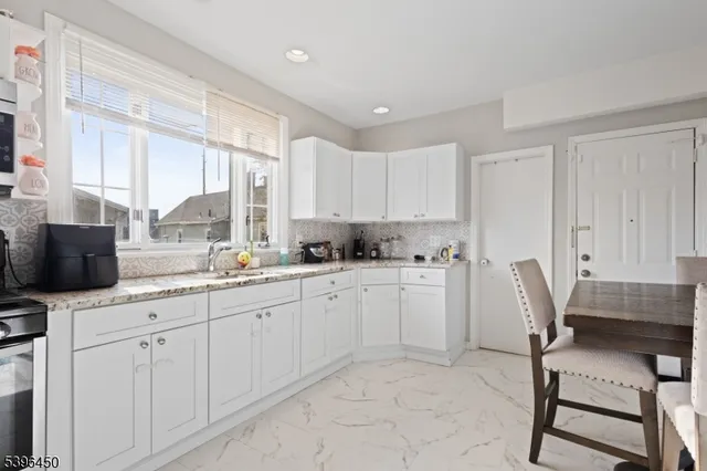 a kitchen with white cabinets and chair