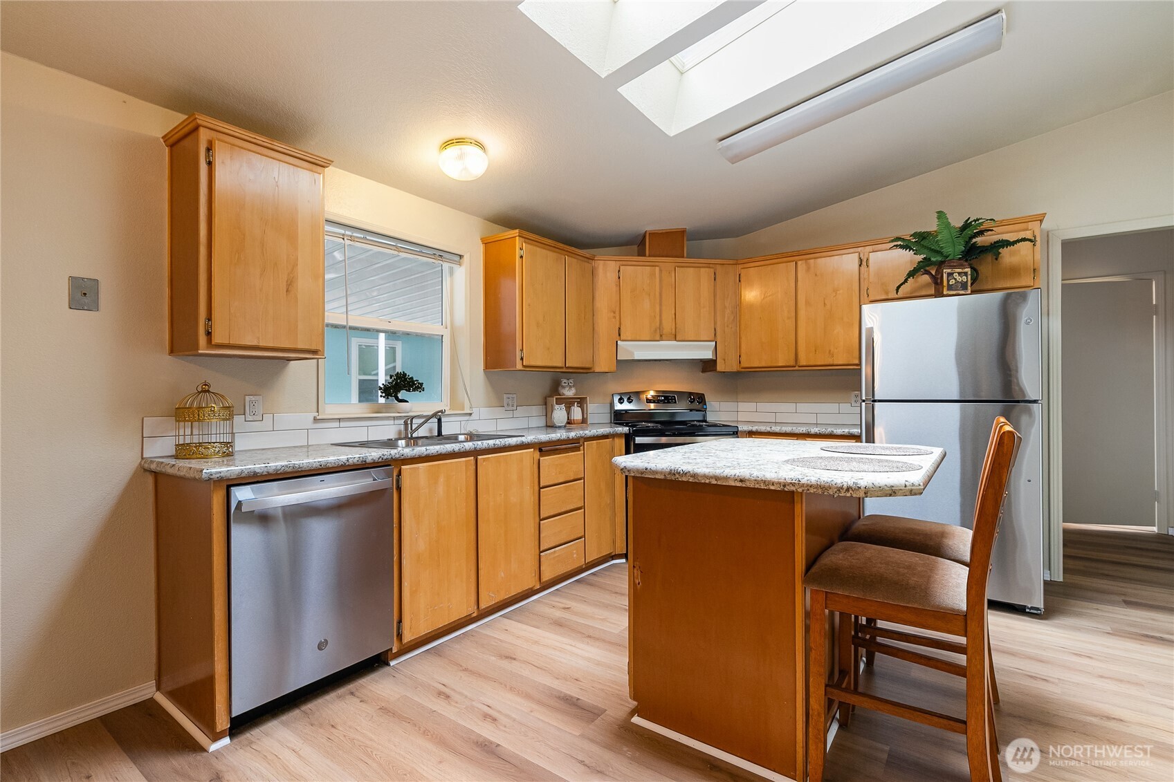 2350 Douglas Road, Unit 30B Ferndale, WA 98248 - Photo 9 of 36 a kitchen with stainless steel appliances granite countertop a refrigerator a sink dishwasher a stove and white countertops with wooden floor