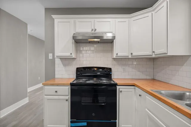 a kitchen with stainless steel appliances granite countertop white cabinets and a stove