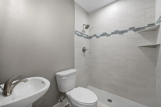 a white toilet sitting next to a bath tub