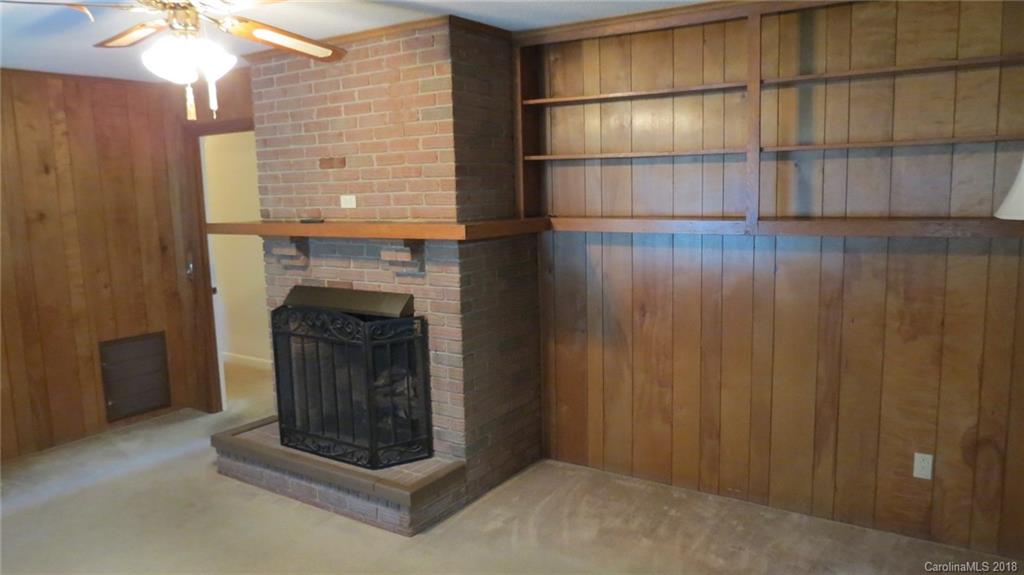 4706 Ridge Road Charlotte, NC 28269 - Photo 12 of 17 a living room with a fireplace and a chandelier